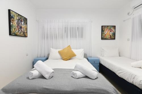 提比里亚Villa-SELAVI 3 unit complex with infinity pool的白色墙壁客房的两张床