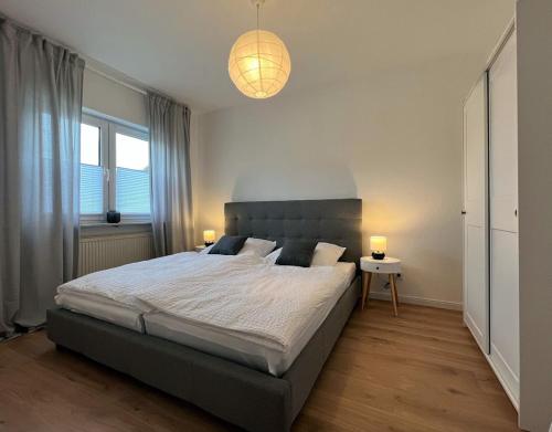 孔茨Ferienwohnung an der Saar的一间卧室配有一张大床和两盏灯。