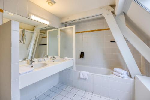 旧蒂尔瑙特普瑞姬科森多克酒店的浴室设有2个水槽、浴缸和镜子