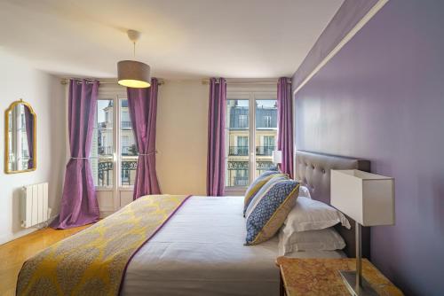 巴黎卢浮宫公寓 - 沼泽的一间卧室配有一张紫色窗帘的床