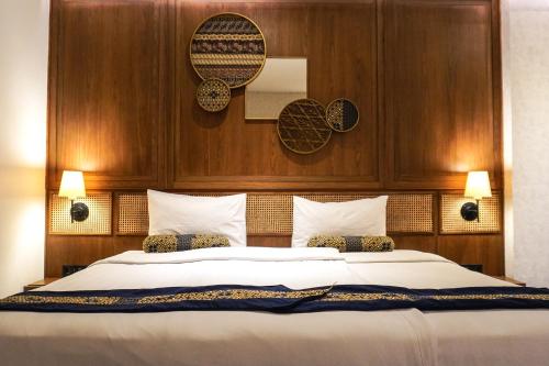 万隆万隆爪哇酒店的一间卧室配有一张大床和木制床头板