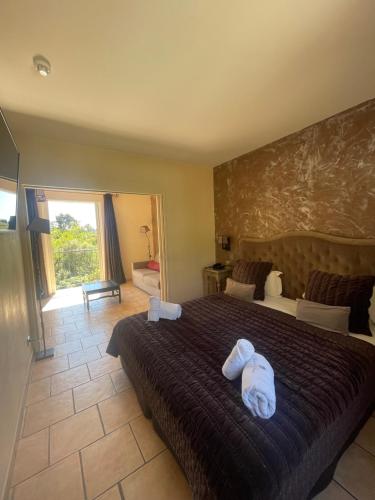 勒拉旺杜Hôtel de La Fossette的一间卧室配有一张大床和两条毛巾