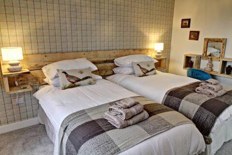 斯特灵Byre 1的两张位于酒店客房的床,配有毛巾