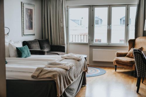 舍夫德克拉丽奥玛约恩连锁酒店的一间卧室配有一张床、一张沙发和一个窗口