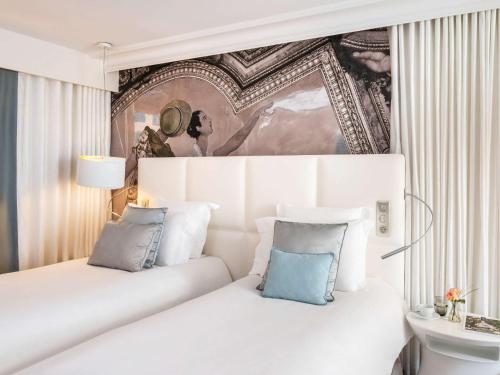 滨海图维列Cures Marines Hotel & Spa Trouville - MGallery Collection的一间卧室配有白色床和蓝色枕头