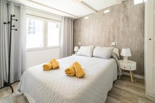 贝尼多姆Apartamento ALMA con terreno privado y parking compartido - a 800m de Playa Poniente的卧室配有白色床和黄色毛巾
