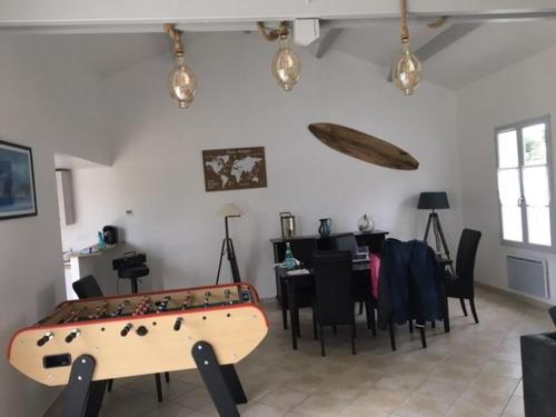 莱居永叙尔维Gite avec piscine privative的一间带乒乓球桌和用餐室的房间