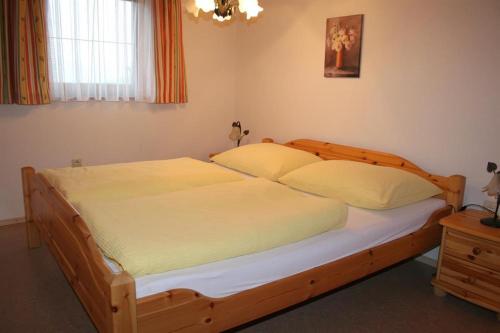 霍赫菲尔岑Ferienwohnungen Foidlhof的一间卧室配有一张大木床和白色床单