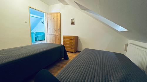 因斯科Apartament Pod Kasztanami - ZIELONY的阁楼卧室设有两张床和窗户。
