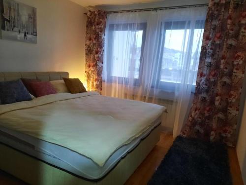萨拉热窝Džoni的一间卧室配有床和带窗帘的窗户