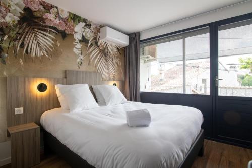 阿维尼翁新城O'Cub Hotel的卧室配有一张大白色床和窗户