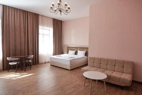 久姆里KUMA Hotel Gyumri的一间卧室配有一张床、一张沙发和一张桌子