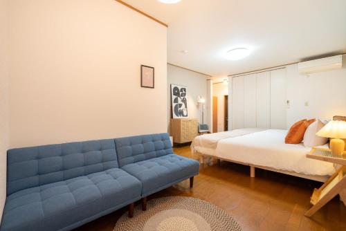 东京HANAMIKAKU-shinjuku/akihabara/asakusa/ginza/tokyo/narita/haneta Japanese House 100㎡的一间卧室配有蓝色的沙发和一张床