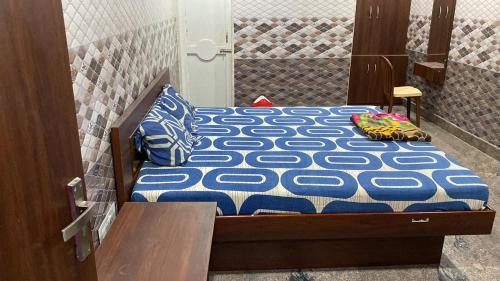 ArakkonamSri Mahalakshmi Deluxe Lodging Arakonam的一张带蓝色和白色床单的床,床上配有枕头
