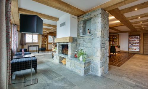 拉赫兹耶尔CGH Résidences & Spas Chalet Les Marmottons的客厅设有石制壁炉和电视。