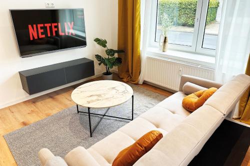 门兴格拉德巴赫Modernes City-Apartment in Mönchengladbach的带沙发和电视的客厅