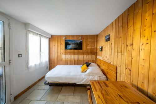 蒙彼利埃Charming Studio of 17 m with garden Montpellier的一间卧室设有一张床和木墙