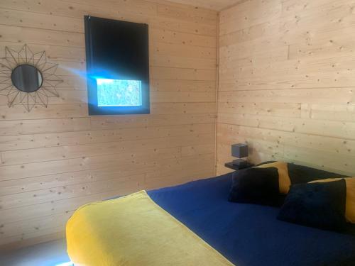蒙托邦Chalet 1 contemporain dans son écrin de verdure的卧室配有一张床铺,墙上配有电视