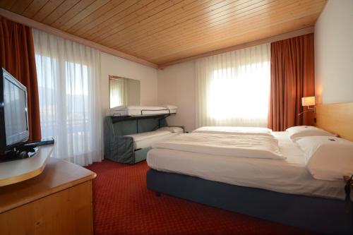 菲耶梅堡Hotel Los Andes的酒店客房设有两张床和电视。