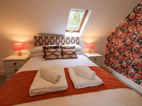 格拉斯米尔North Lodge的一间卧室配有一张床,上面有两条毛巾