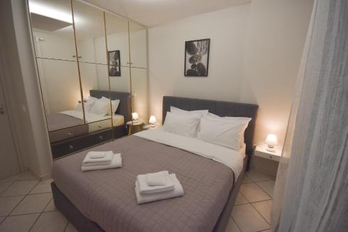 马科普隆K&C Rooms- Apartments的一间卧室配有一张大床和两条毛巾