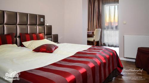 埃森施马丁堡硕餐厅酒店的一间卧室配有一张带条纹毯子的大床