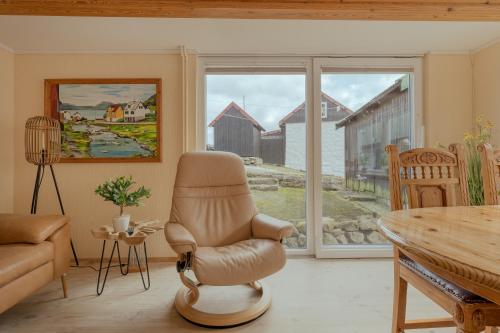 Við GjógvCozy Cottage / 3BR / Hiking / Nature的客厅配有椅子和桌子