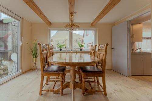 Við GjógvCozy Cottage / 3BR / Hiking / Nature的一间带木桌和椅子的用餐室