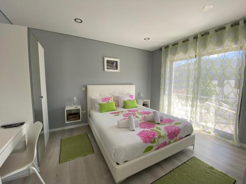 吉尔斯Cantinho Verde T1的一间卧室配有一张床、一张书桌和一个窗户。