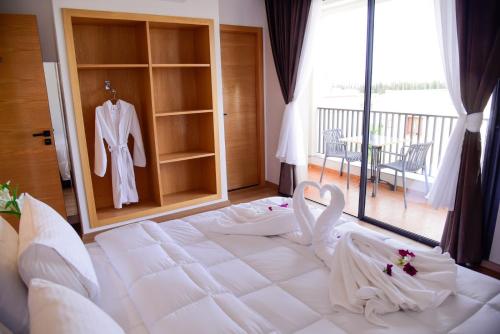 梅克内斯Hotel beaux arts的卧室配有一张大白色的床和浴袍