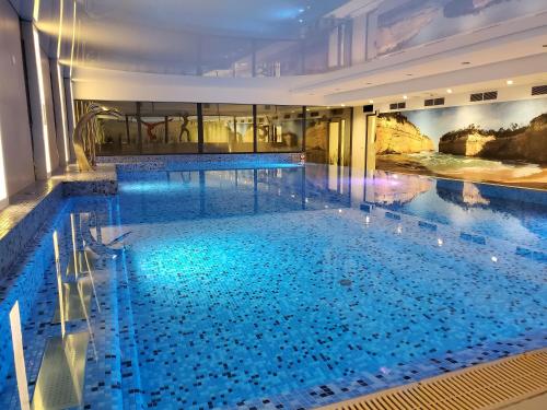 博茨科沃Antonińska Resort SPA的大楼内一个蓝色的大型游泳池