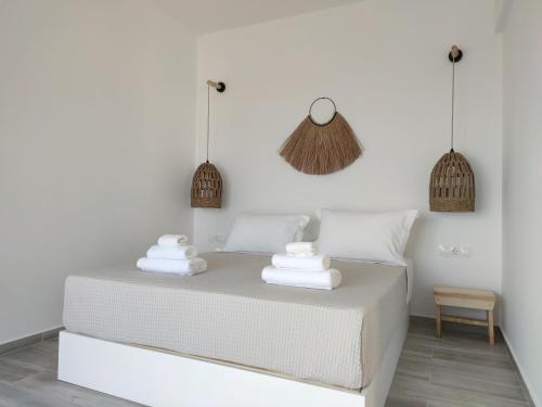 巴特斯欧Eolia luxury suites Andros的卧室配有白色床和毛巾