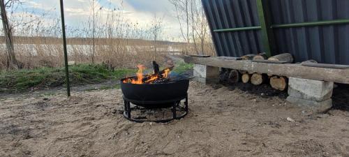埃莱克特伦艾Vigio Brasta camping的旁边是烤炉,炉火在板凳上