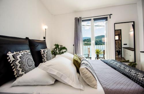 阿尔戈斯托利翁A & B Minimal Suite with Sea View in Argostoli的卧室配有带枕头的床铺和窗户。