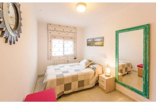 AvinyonetCa l'Antoni的一间卧室配有床、镜子和红色椅子