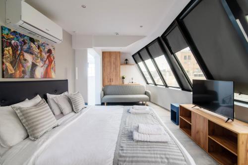 雅典Olvia Suites的一间大卧室,配有一张大床和一台电视