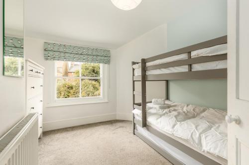 牛津Beautiful Edwardian Central Oxford home的一间卧室配有双层床和窗户。