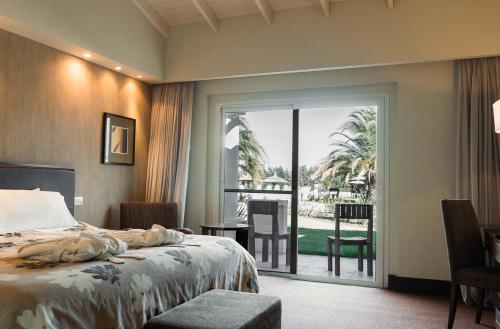 MelincuéMelincue Casino & Resort的一间卧室设有一张床和一个滑动玻璃门