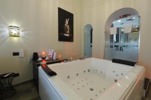 那不勒斯Il Salotto della Regina的浴室设有大浴缸,墙上挂着猫的照片