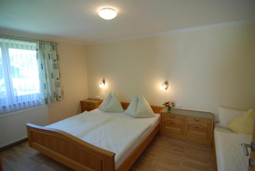 莱奥冈Ferienwohnung Stöckl的一间卧室配有一张带白色床单的床和一扇窗户。