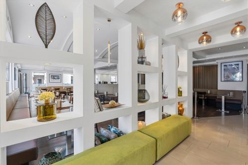 腓特烈港阿德勒酒店的一间带绿色沙发的客厅和一间用餐室