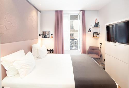 巴黎旺多姆圣日耳曼酒店的酒店客房设有白色的床和电视。
