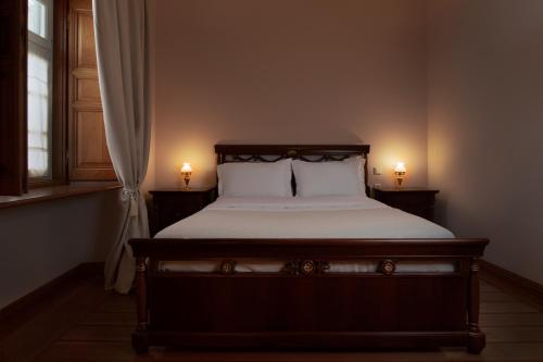 伊兹拉Antoinette Mansion的一间卧室配有一张带两个灯的床