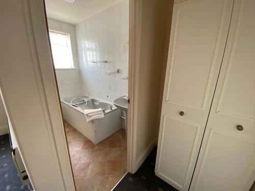 桑当Friends Hotel的白色的浴室设有水槽和卫生间。