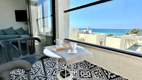 纳哈里亚GW945 Gugel Waves Amazing Seaview Apartments的阳台配有桌子,享有海景。