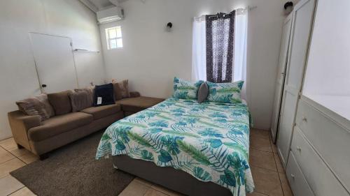 洛尼湾村Caribbean Dream Vacation Property CD3的一间卧室配有一张床和一张沙发