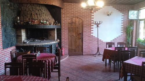米内拉尔尼巴尼Семеен хотел НАЦИОНАЛ的一间带桌椅和壁炉的餐厅