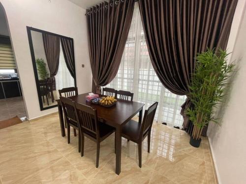 Kampung KerangiVilla President Homestay -4 bedroom Aircond WIFI Vacations Home的一间带桌椅和窗帘的用餐室
