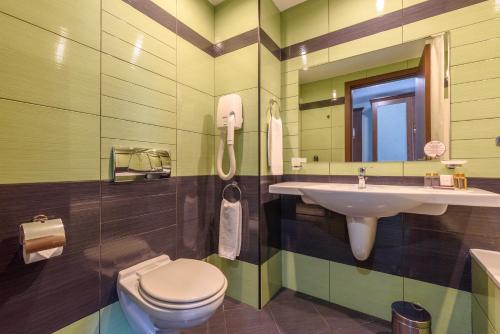 阳光海滩狮阳海滩酒店的一间带水槽、卫生间和镜子的浴室