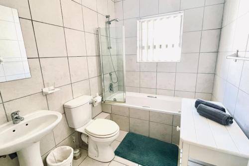 莫塞尔湾Stylish Hartenbos Apartment的白色的浴室设有卫生间和水槽。